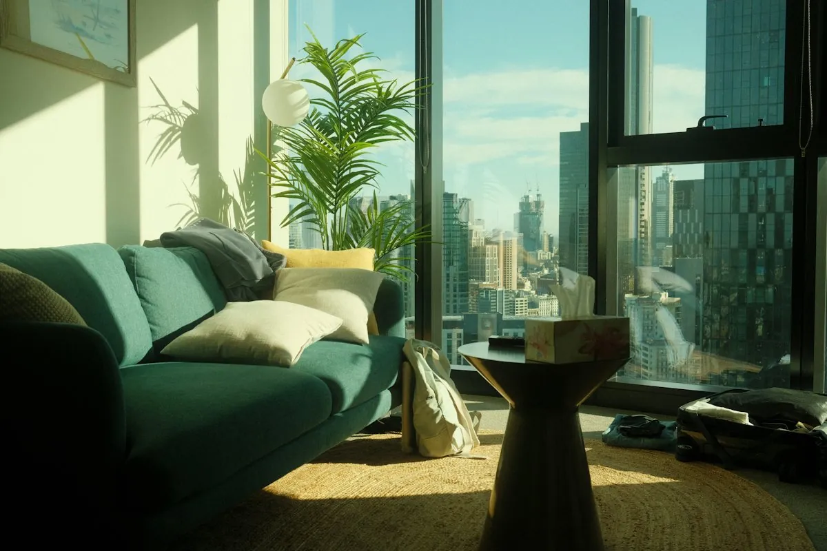 Living room with a green sofa and floor-to-ceiling windows